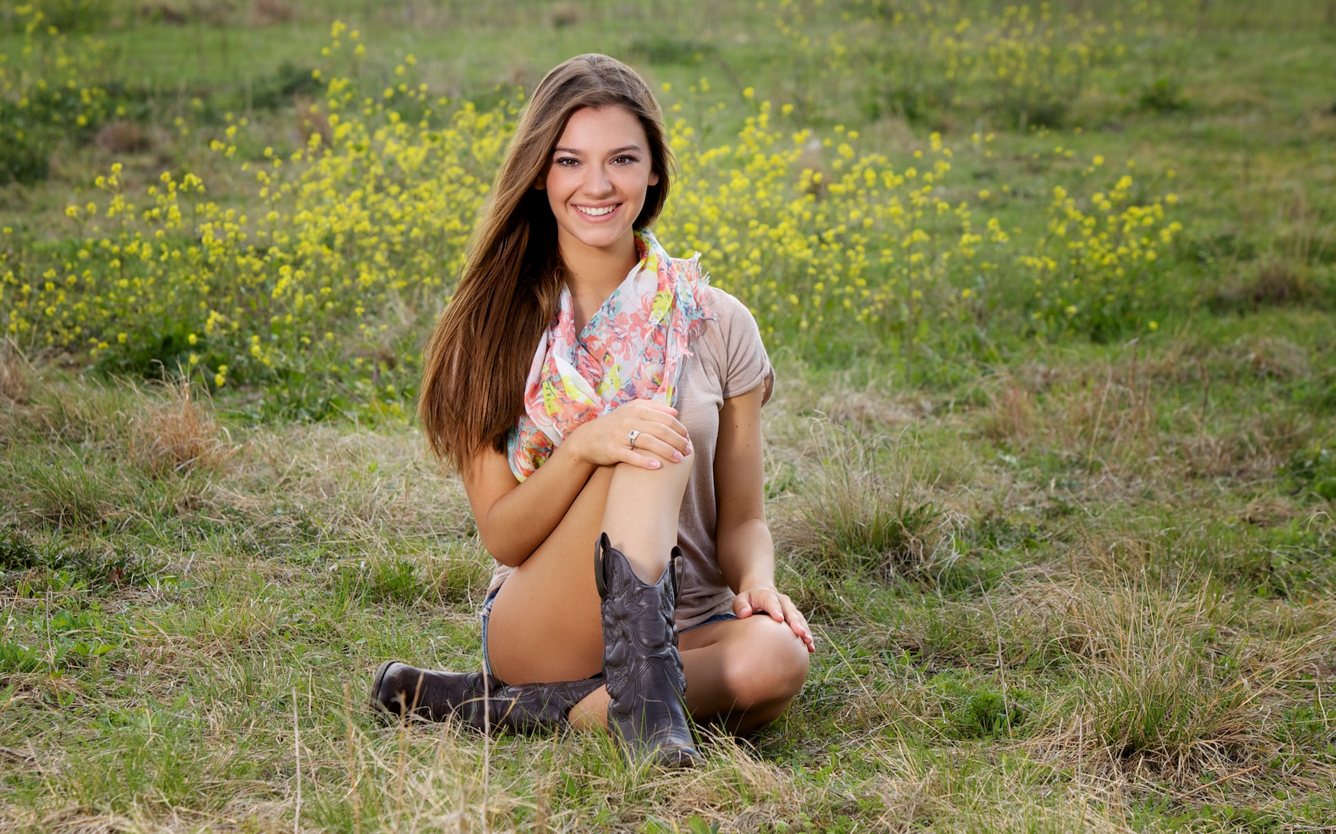 High school senior with cowboy boots in the wildflowers in Allen TX